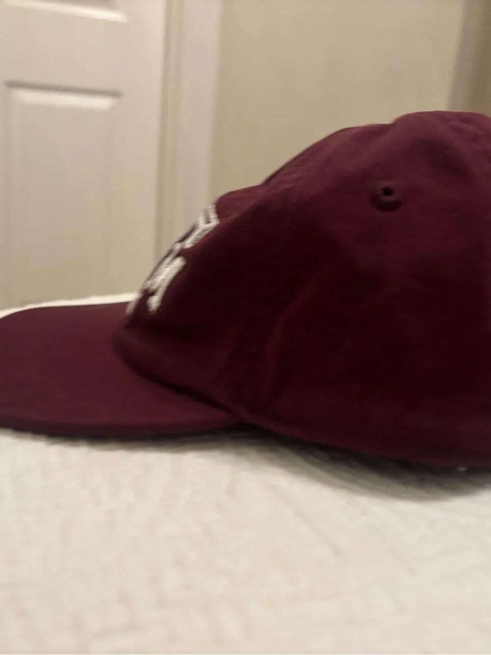 A&M baby baseball cap, elastic back w/ white embroidered A&M Logo & Lil’Aggie